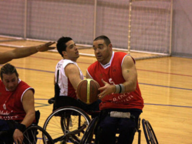 Jugadores de baloncesto en silla de ruedas en acción durante un partido.