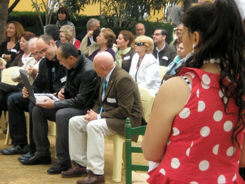 Auditorio lleno de personas en una conferencia o evento público al aire libre.