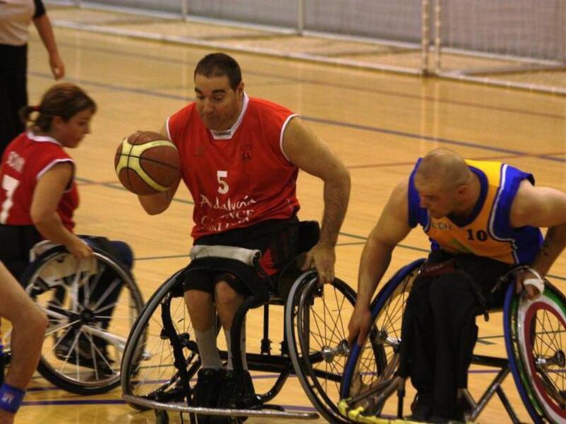 Jugadores de baloncesto en silla de ruedas en acción durante un partido.