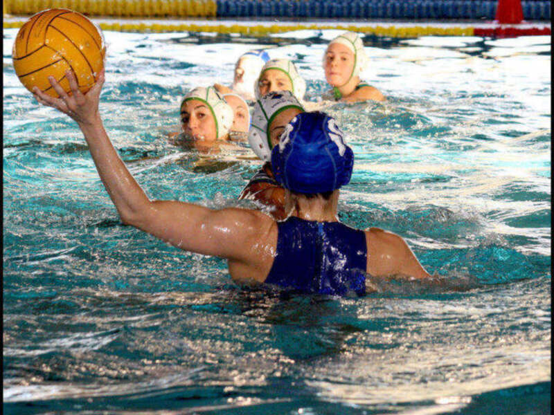 Jugadores de waterpolo en acción durante un partido en piscina.
