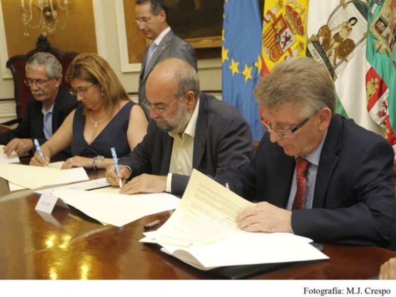 Reunión formal con firma de documentos en un entorno institucional.