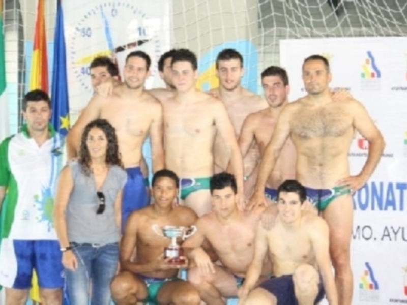 Equipo de natación celebrando con el trofeo en un torneo deportivo.