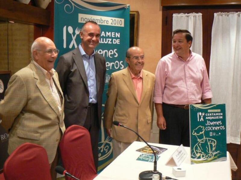 Cuatro personas sonrientes en una conferencia, con un cartel que dice 'noviembre 2010' y otro que dice 'IX Congreso Andaluz de Jóvenes Cocineros'.