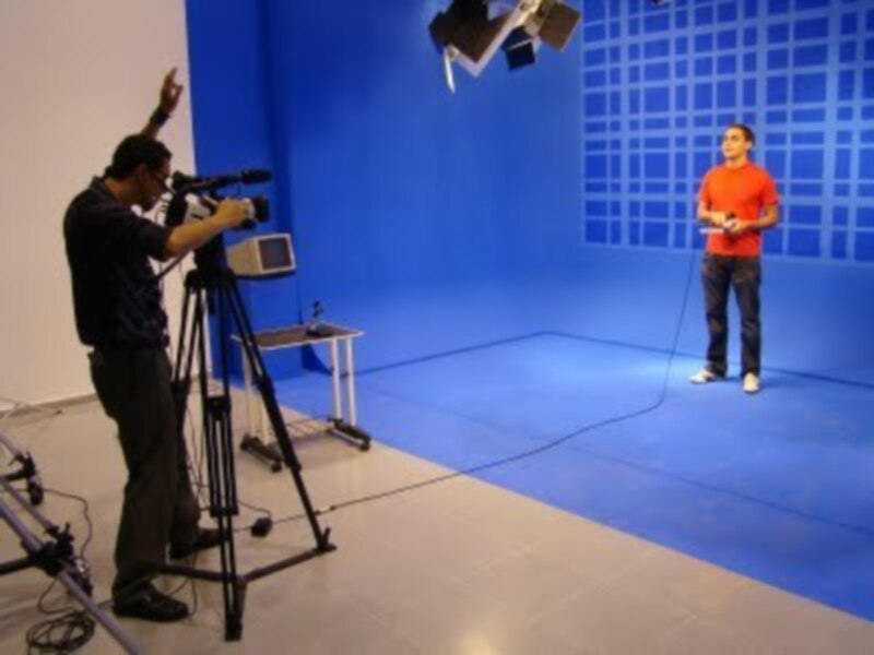 Producción de video en estudio con fondo azul y equipo de grabación