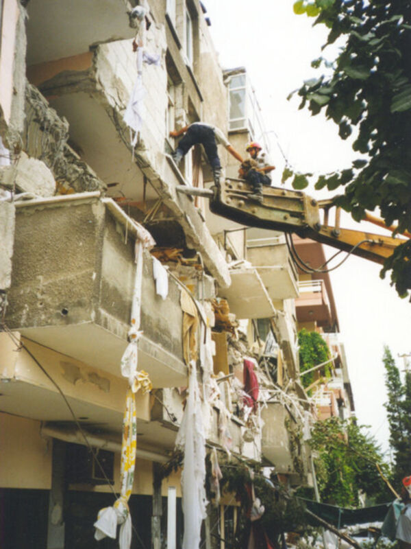 Trabajadores demoliendo un edificio en ruinas.