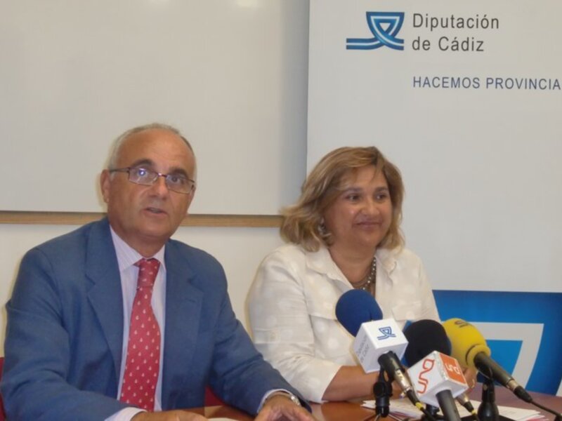 Diputación de Cádiz en una conferencia de prensa con dos personas en el fondo.