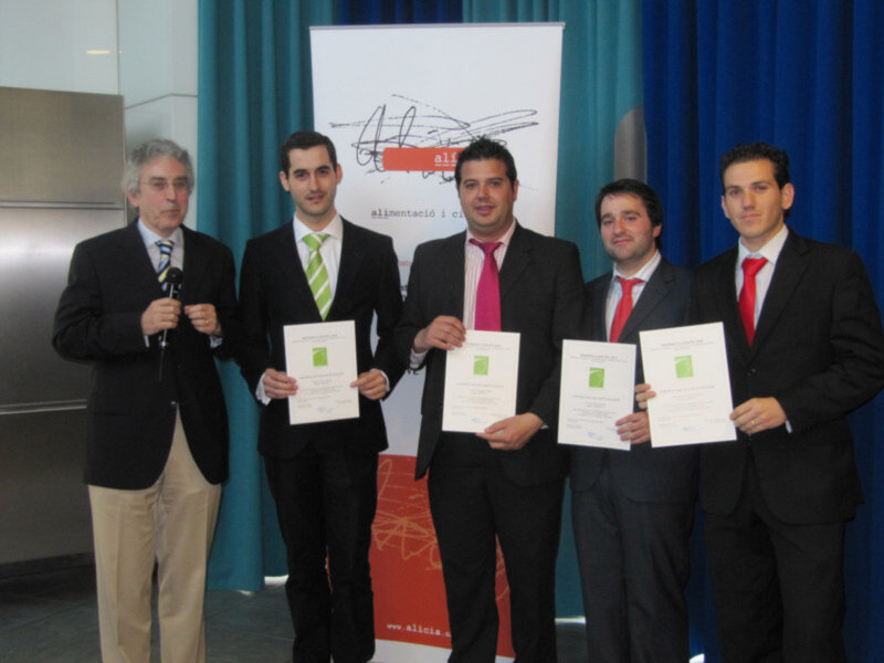 Premiación en un evento de alimentación y ciencia con cuatro jóvenes recibiendo certificados.