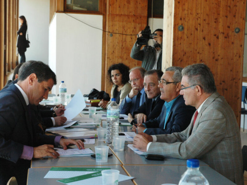 Reunión de negocios en una sala de reuniones con documentos y agua mineral en la mesa.