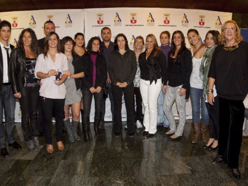 Grup de persones posant per una foto oficial en un espai amb pancartes oficials.
