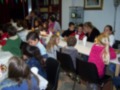 Niños compartiendo una comida en una sala de reuniones con mesas y sillas.