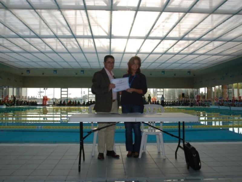 Entrega de certificado en una piscina cubierta.
