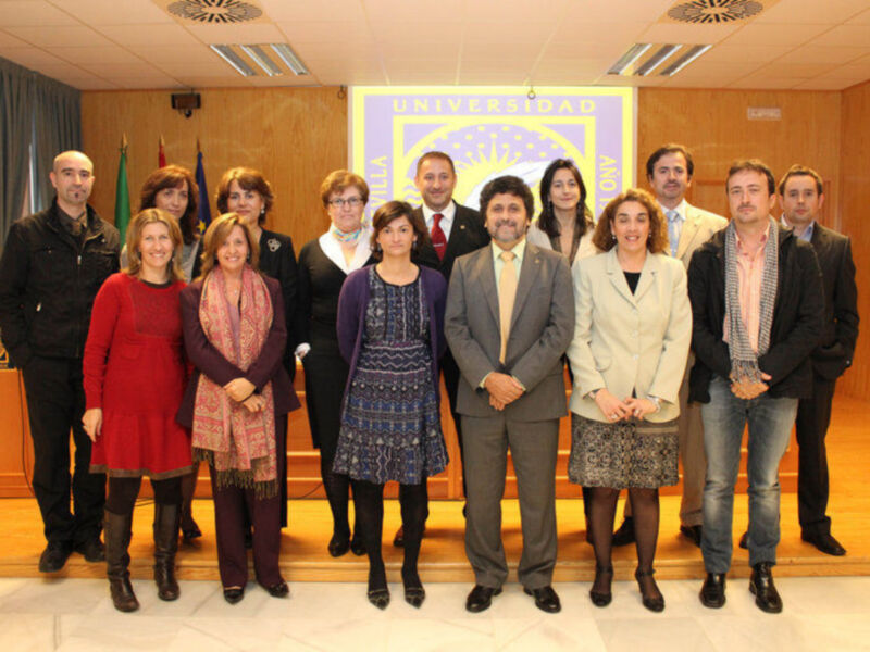 Grupo de personas posando para una foto en un salón universitario.