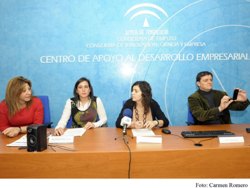Tres personas sentadas en una mesa con un fondo azul que dice 'Centro de Apoyo al Desarrollo Empresarial'.
