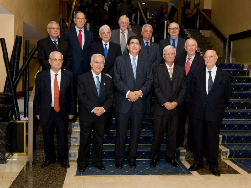 Grupo de hombres en trajes formales posando juntos en un evento formal.