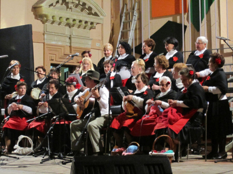 Un grupo de personas en trajes tradicionales tocando instrumentos musicales en una ceremonia formal.