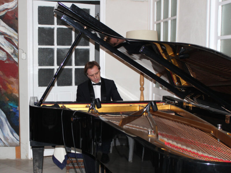 Concierto de piano en un ambiente elegante con pianista en traje negro