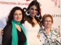 Tres generaciones de mujeres posando juntas en un evento de moda internacional en Sevilla.