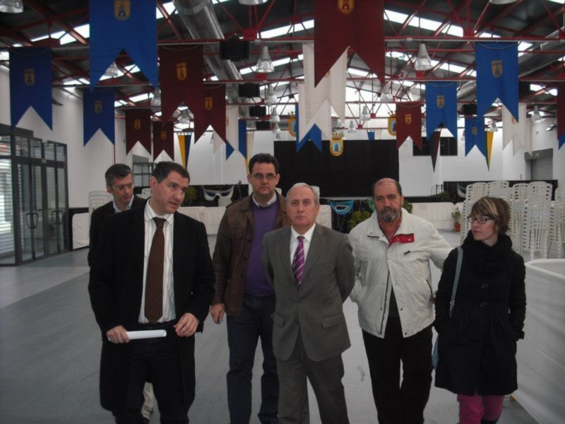 Un grupo de personas posa para una foto en un espacio decorado con banderines de colores.