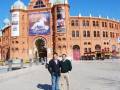 Dos personas posan frente a la emblemática Plaza de Toros de Lisboa, conocida como 'Ovo' (El Huevo), bajo un cielo azul claro.