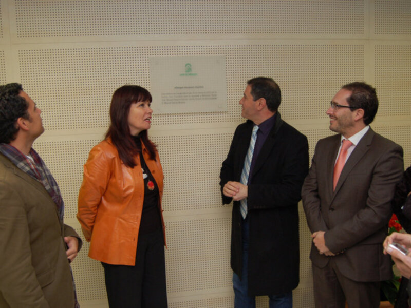 Personas en una reunión o evento formal, intercambiando ideas en un ambiente profesional.