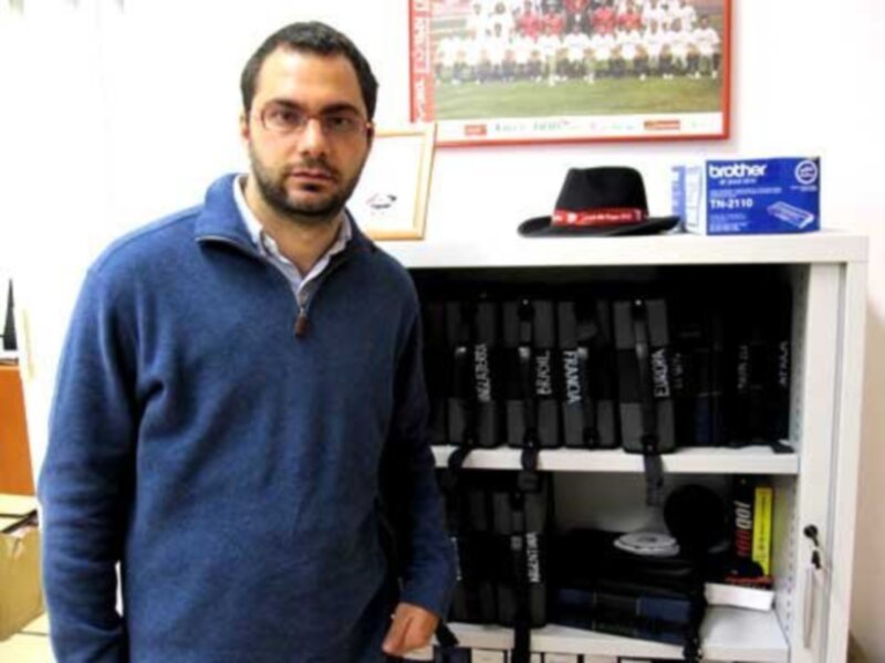 Persona en su oficina con estantería llena de libros y accesorios de oficina.