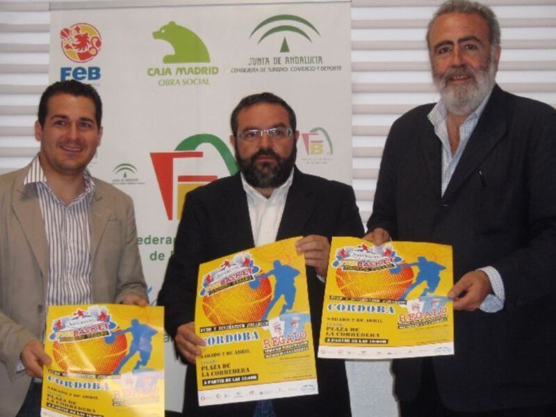 Tres hombres sonrientes sostienen pósters promocionales de un evento deportivo en Córdoba, con logos de diferentes organizaciones en el fondo.