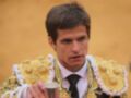 Un torero en traje tradicional de oro y blanco, con un fondo amarillo.