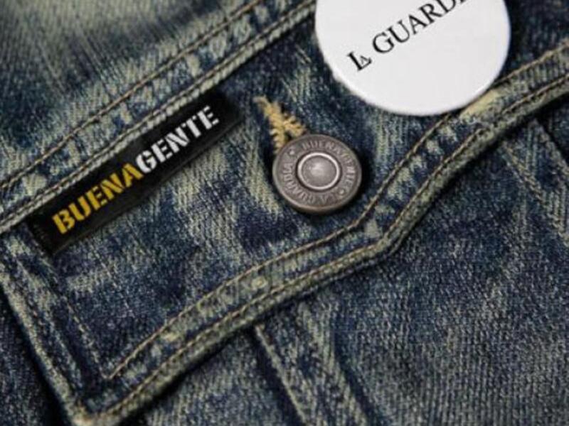 Detalle de un pantalón de mezclilla con etiquetas 'Buena Gente' y 'La Guardia'.