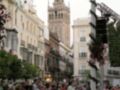 Calleja de Triana, Sevilla, con la Giralda al fondo y una multitud en el primer plano.