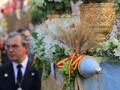 Una procesión religiosa con una carroza decorada con flores blancas y un hombre en uniforme.