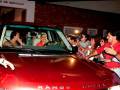 Una familia feliz se toma una foto junto a un Range Rover Rojo. La imagen muestra a varios miembros de la familia, incluyendo adultos y niños, sonriendo y posando para la foto. El Range Rover Rojo destaca como el centro de atención en esta escena familiar y festiva.