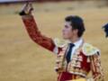 Un torero en traje tradicional celebrando una corrida de toros.