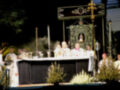 Eucaristía en un altar con sacerdotes y ofrendas, con un ambiente religioso y decoración ornamental.