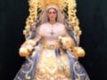 Imagen de la Virgen María vestida con trajes tradicionales españoles, rodeada por una corona dorada y un manto azul con detalles dorados.