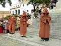 Personas vestidas con trajes tradicionales en una plaza, rodeadas de espectadores.