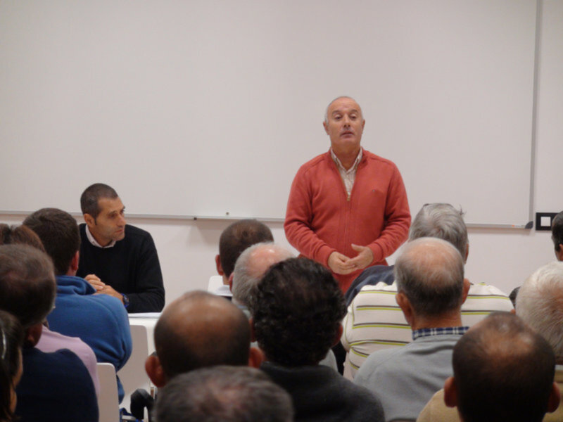 Un hombre habla frente a un grupo de personas en una sala de conferencias.