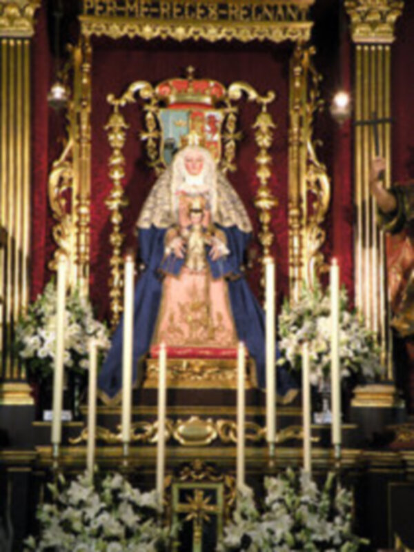 Altar con imagen de la Virgen del Carmen en un entorno procesional con velas y adornos dorados.