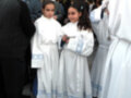 Niños vestidos de blanco con detalles azules, posiblemente en una ceremonia religiosa o festiva.