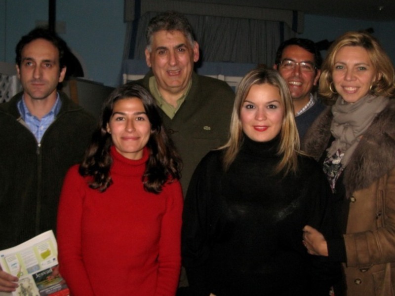 Una familia en una reunión familiar, todos sonrientes y vestidos con ropa casual.