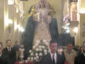 Una imagen de la Virgen María en una iglesia, rodeada por fieles.