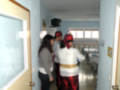 Personas vestidas de manera exagerada en un hospital, con una camilla y ventanas al fondo.