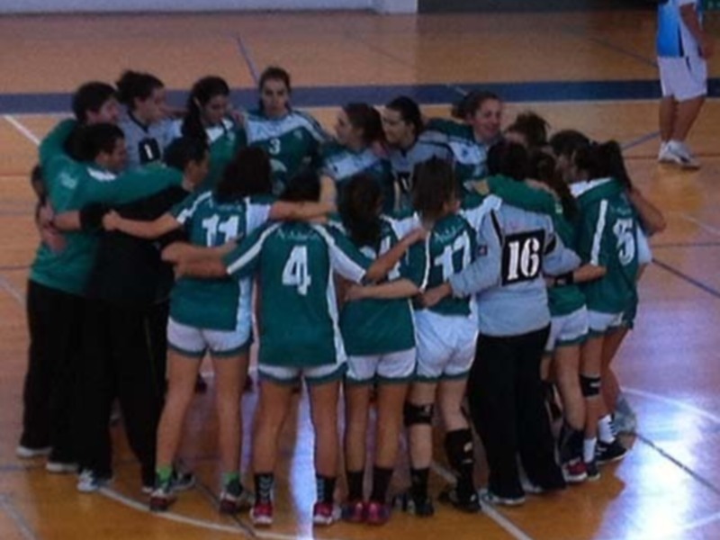 Equipo de baloncesto femenino en una reunión de equipo en el centro del campo.