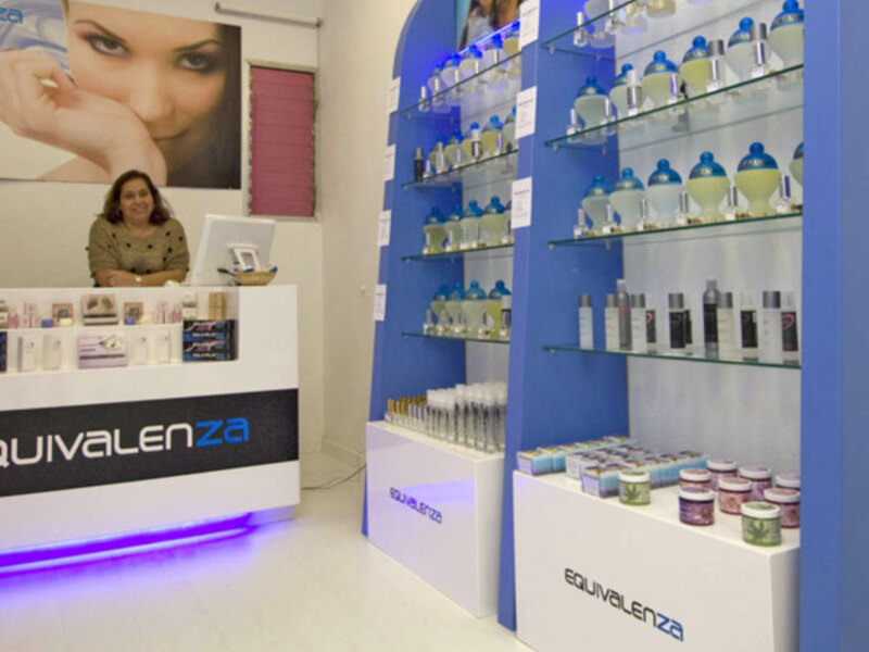 Interior de una tienda de cosméticos con productos en estantes y una recepción.