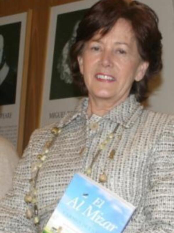 Autora sosteniendo el libro 'El Al Mizan' en un evento literario.