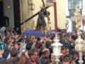 Una procesión religiosa con una imagen de Jesús crucificado, acompañada por fieles y oficiales.