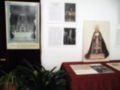 Una exposición en una pared con imágenes históricas de la Virgen María, junto a textos informativos sobre su historia y significado.