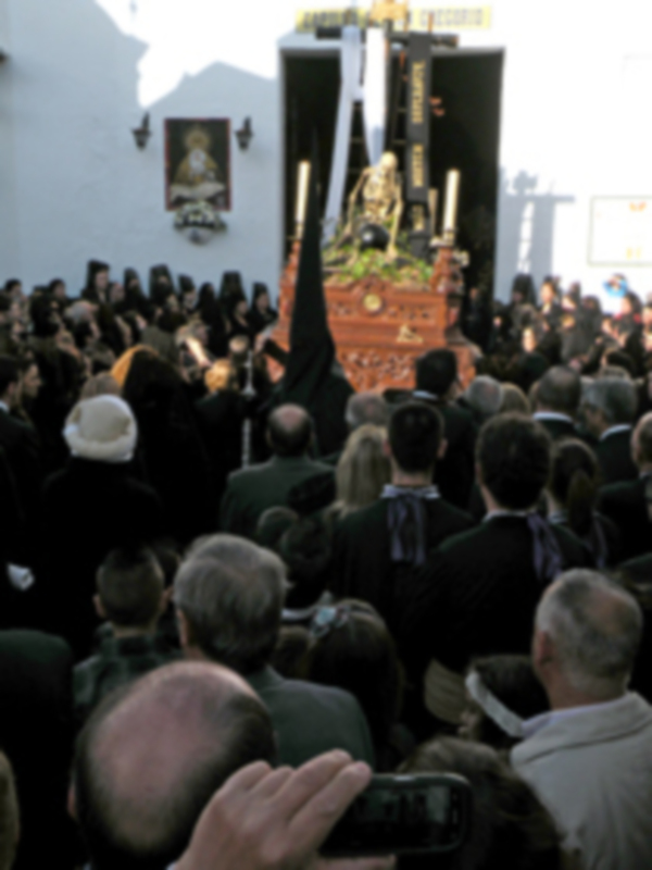Una multitud de personas en un evento formal, con una escultura en el centro del escenario.