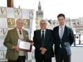 Premio a un empresario en una celebración con la Giralda de Sevilla al fondo.