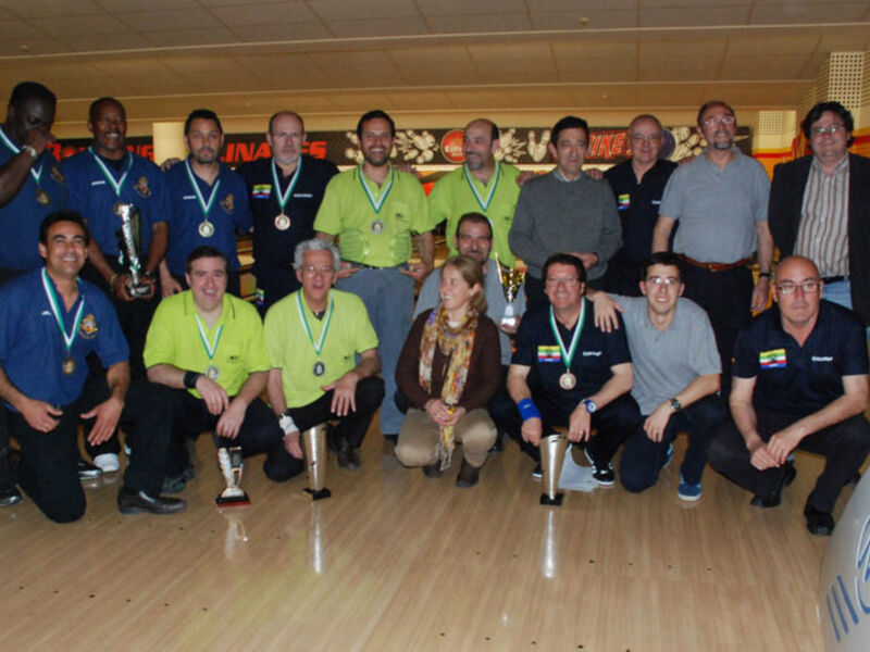 Equipo de boliche con trofeos y medallas en un torneo de competencia.