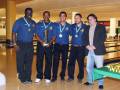 Equipo de bowling celebrando con trofeo, vestidos uniformes azules y medallas.
